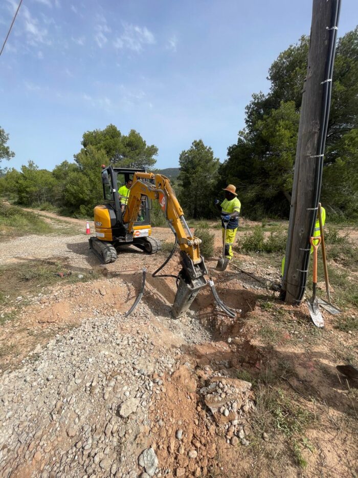 Excavadora pequeña utilizada para realizar el minizanjado en una zona rural.