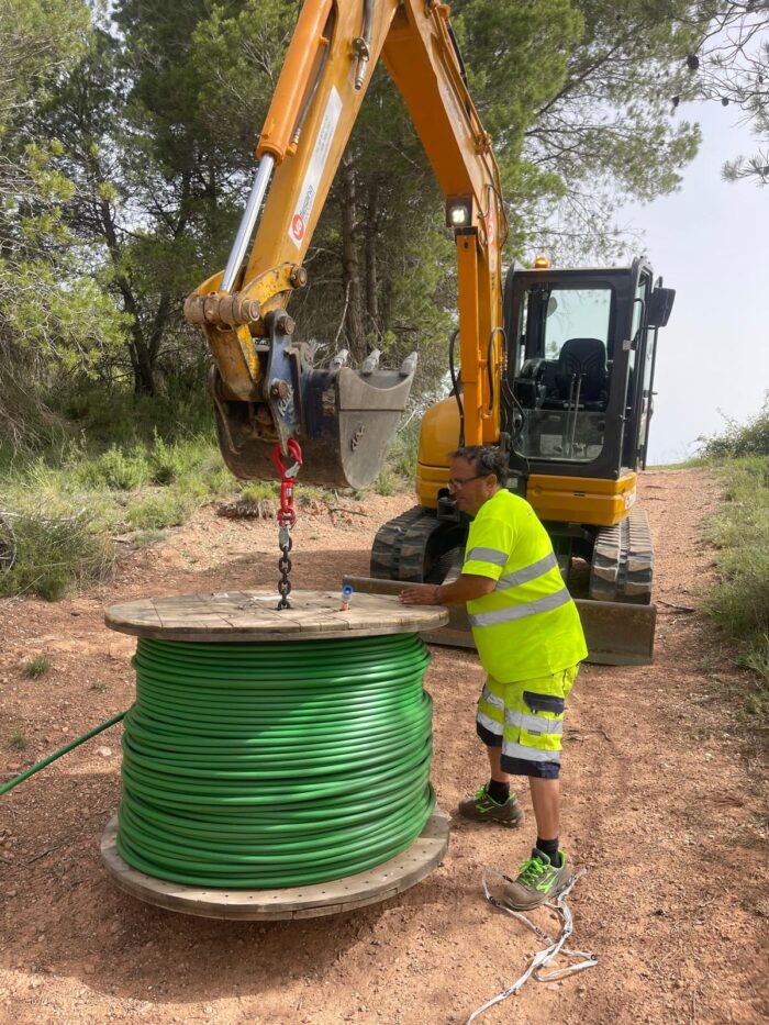 Operario utilizando el desbobinador POWERTWISTER durante el despliegue de fibra óptica en zona rural.